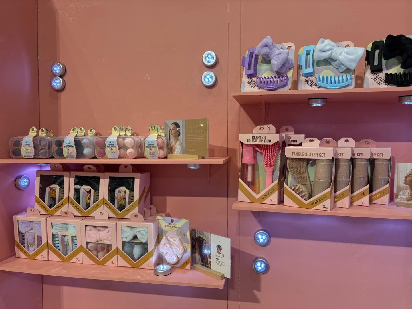 Voralie beauty sets merchandised on pink shelves